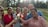 A diverse group of happy clients sharing their positive real estate experiences outdoors.