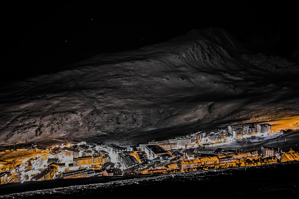 uma vista noturna de uma cidade nas montanhas