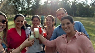 A group of diverse people enjoying energy drinks together outdoors on a sunny day.