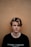 man in black crew-neck shirt near brown wall