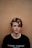 man in black crew-neck shirt near brown wall