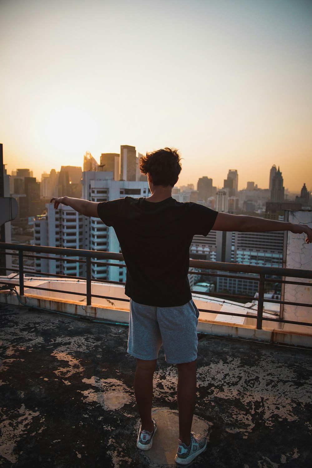 homme portant un t-shirt noir au coucher du soleil