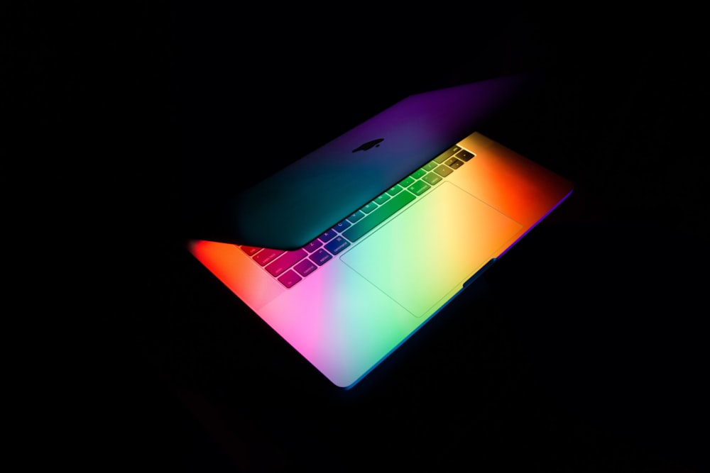 MacBook prateado na superfície preta