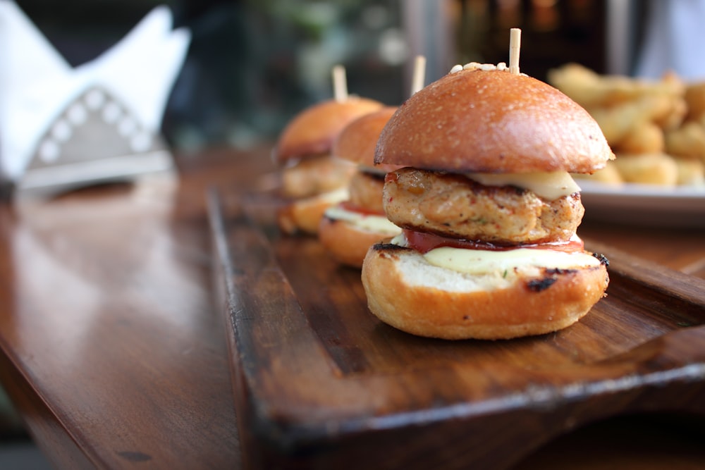 three burgers on wooden table