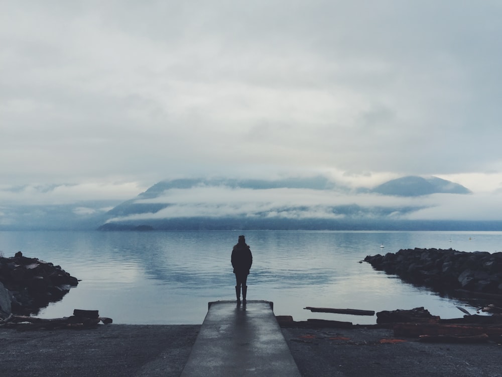 person looking at the foggy mountain