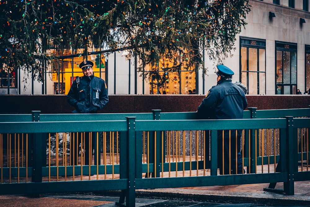 ベンチに座る黒いジャケットと青い帽子の男