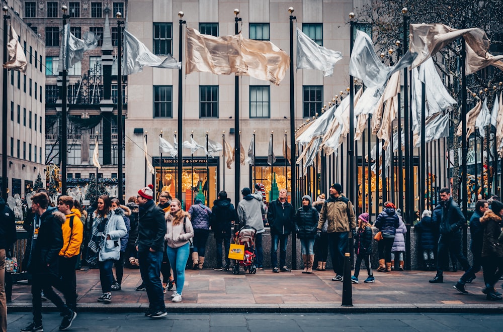 people standing near white and brown flags during daytime