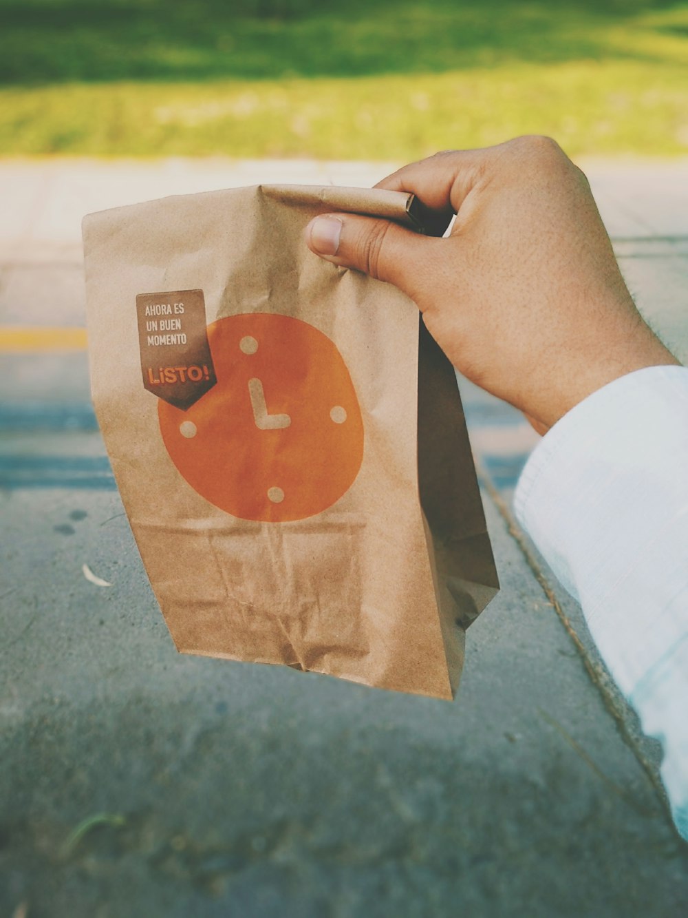 personne tenant un sac en papier Listo brun