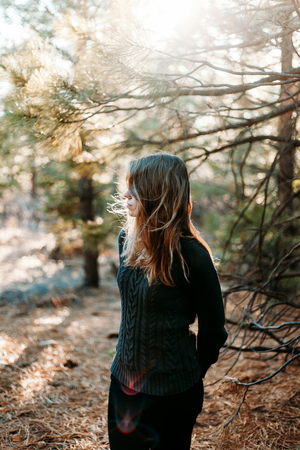 selective focus photography of woman standing beside tree