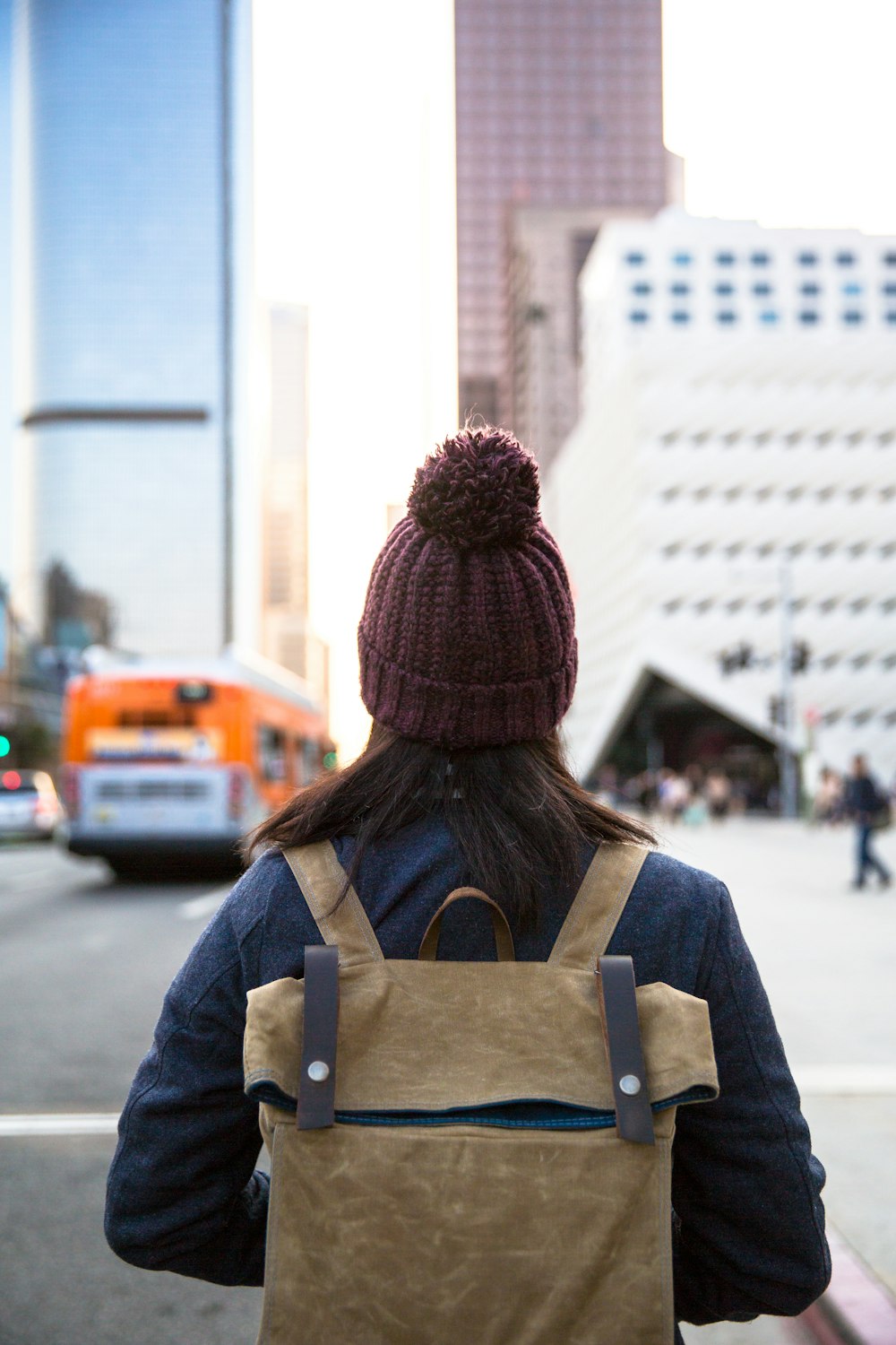 Mujer con mochila frente al edificio