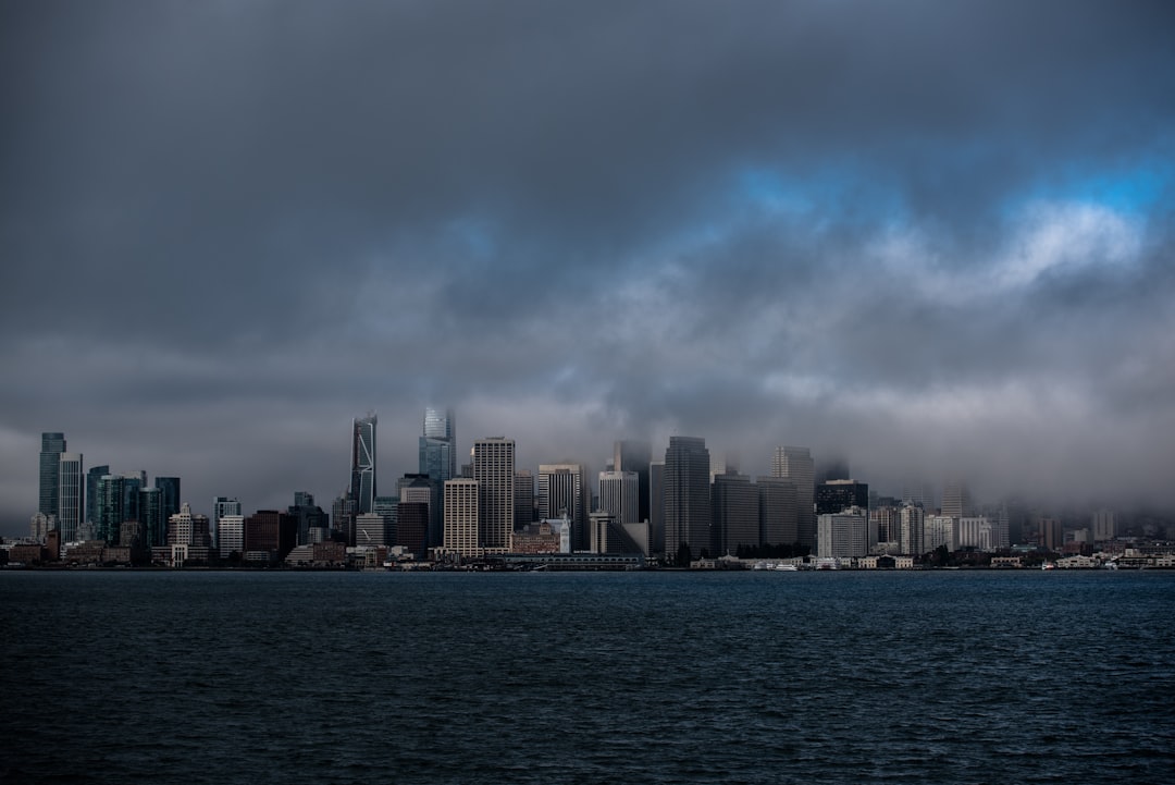 city with high-rise buildings viewing sea under gray skies