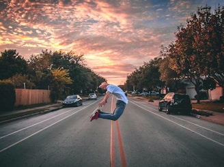 man jumping on road during golden hour