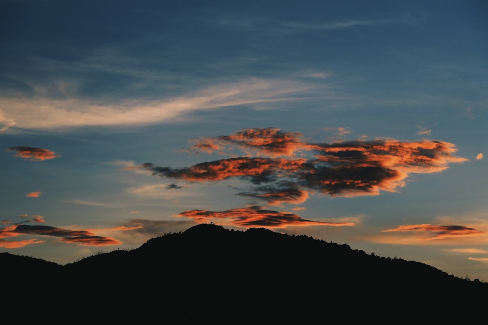silhouette photography of mountain under nimbus clouds