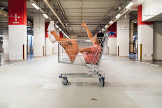 woman sitting in shopping cart at parking lot
