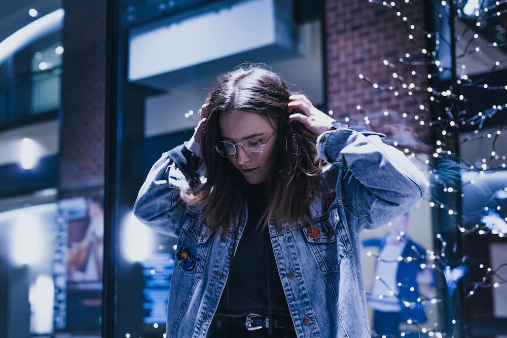 woman fixing her hair near striplights on the wall