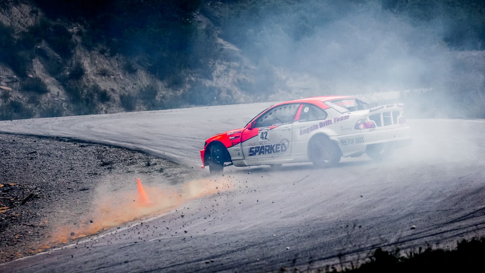 red and white stock car on road