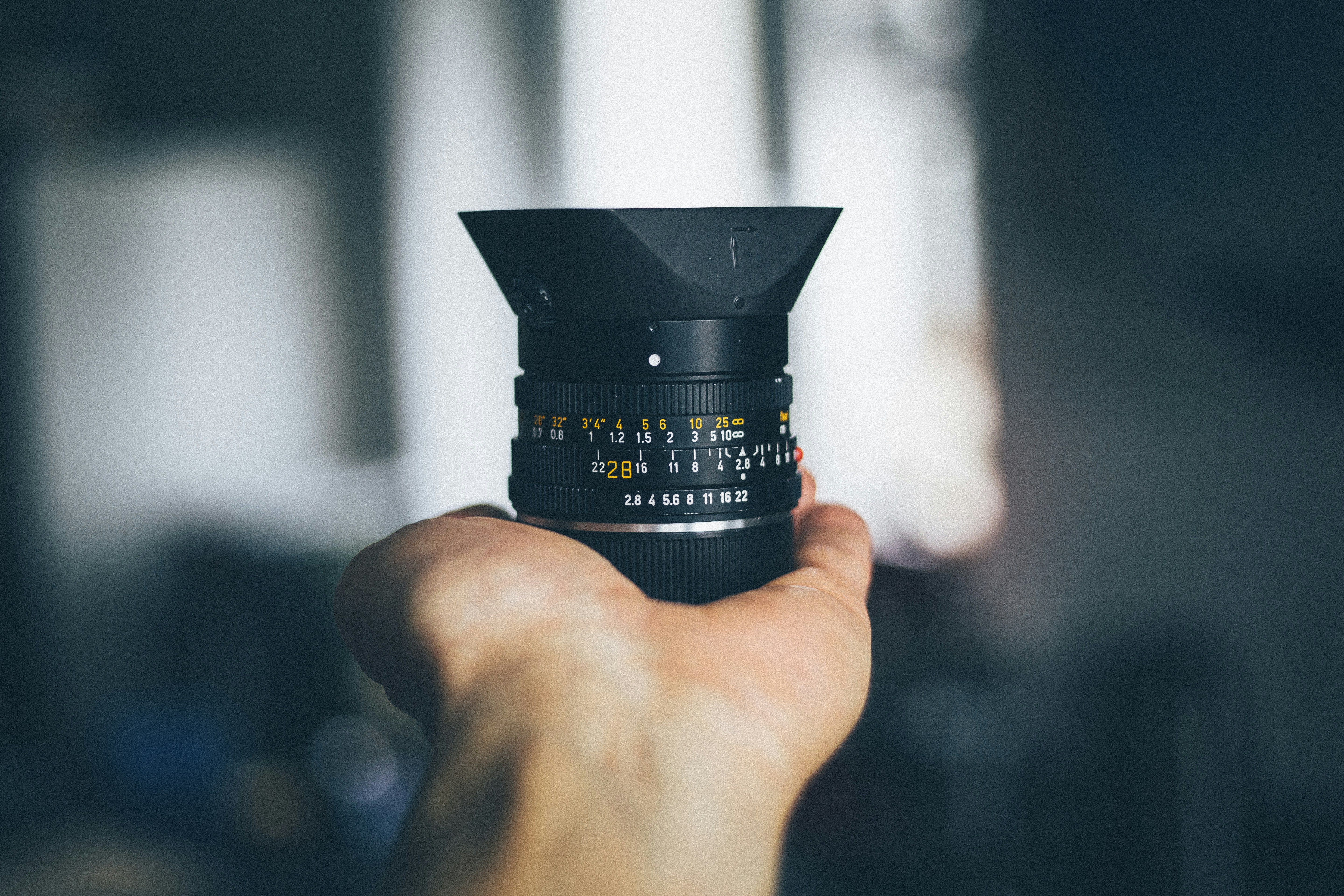 person holding black DSLR camera lens, 