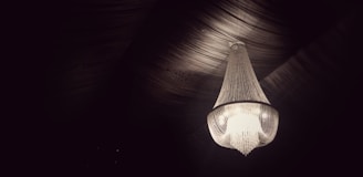 A stylish chandelier hanging in an elegant dining room.
