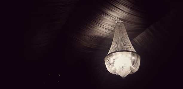 A stylish chandelier hanging in an elegant dining room.