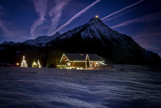 A cozy Christmas card with a snowy cabin and twinkling lights.