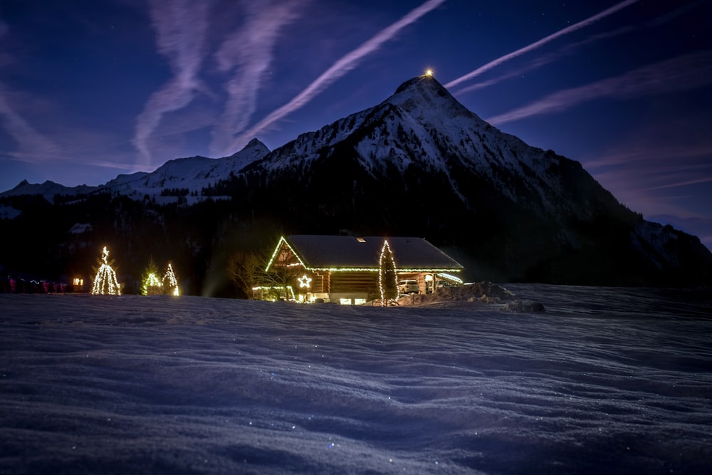 casa illuminata vicino alla montagna durante la notte
