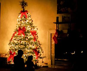 Santa Claus warmly greeting children in a cozy living room decorated with Christmas lights and stockings.