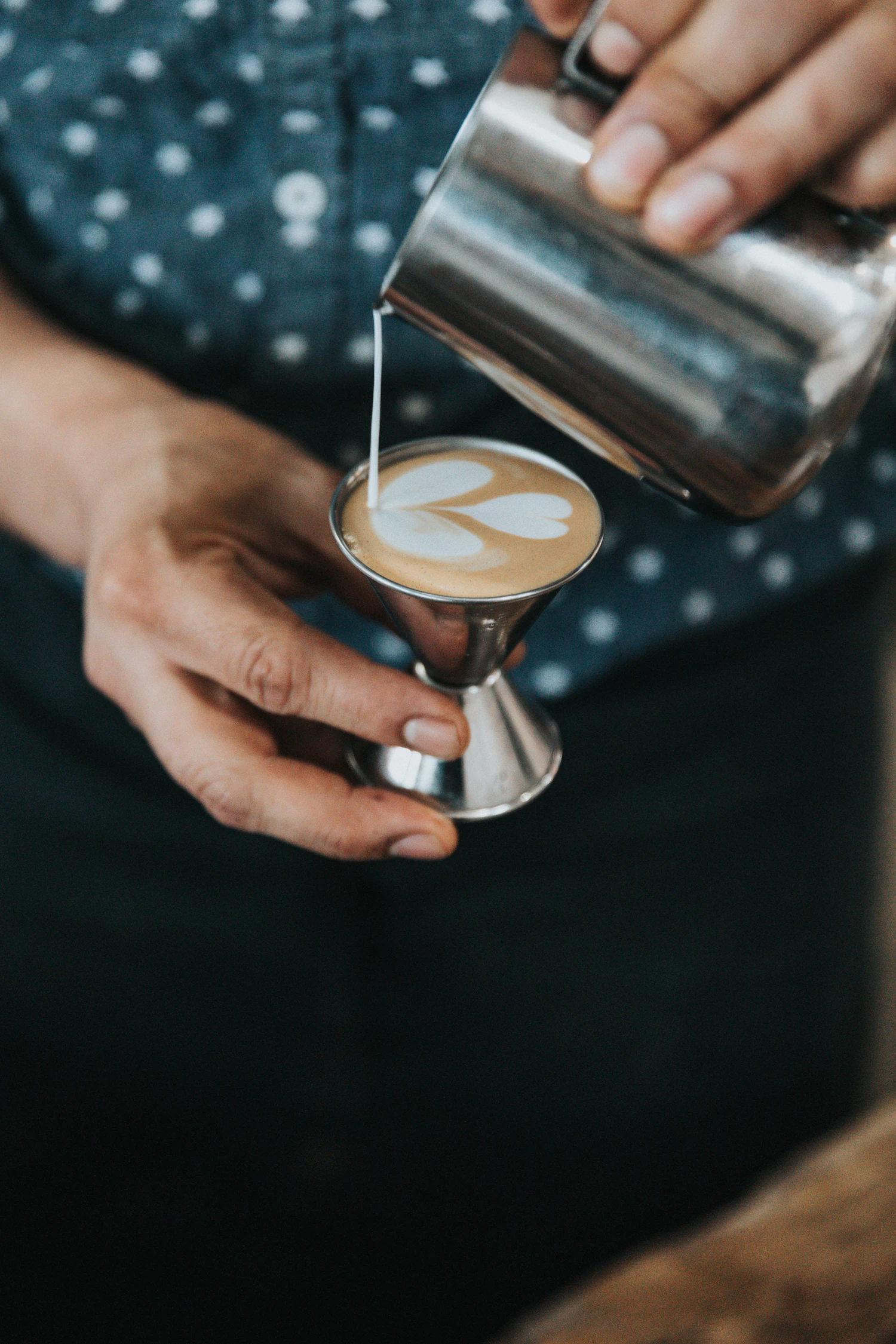 Close-up of real latte art pouring with a stainless-steel pitcher