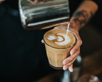 man pouring milk in coffee