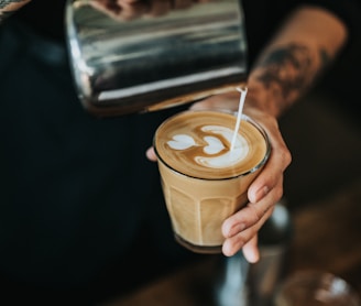 man pouring milk in coffee