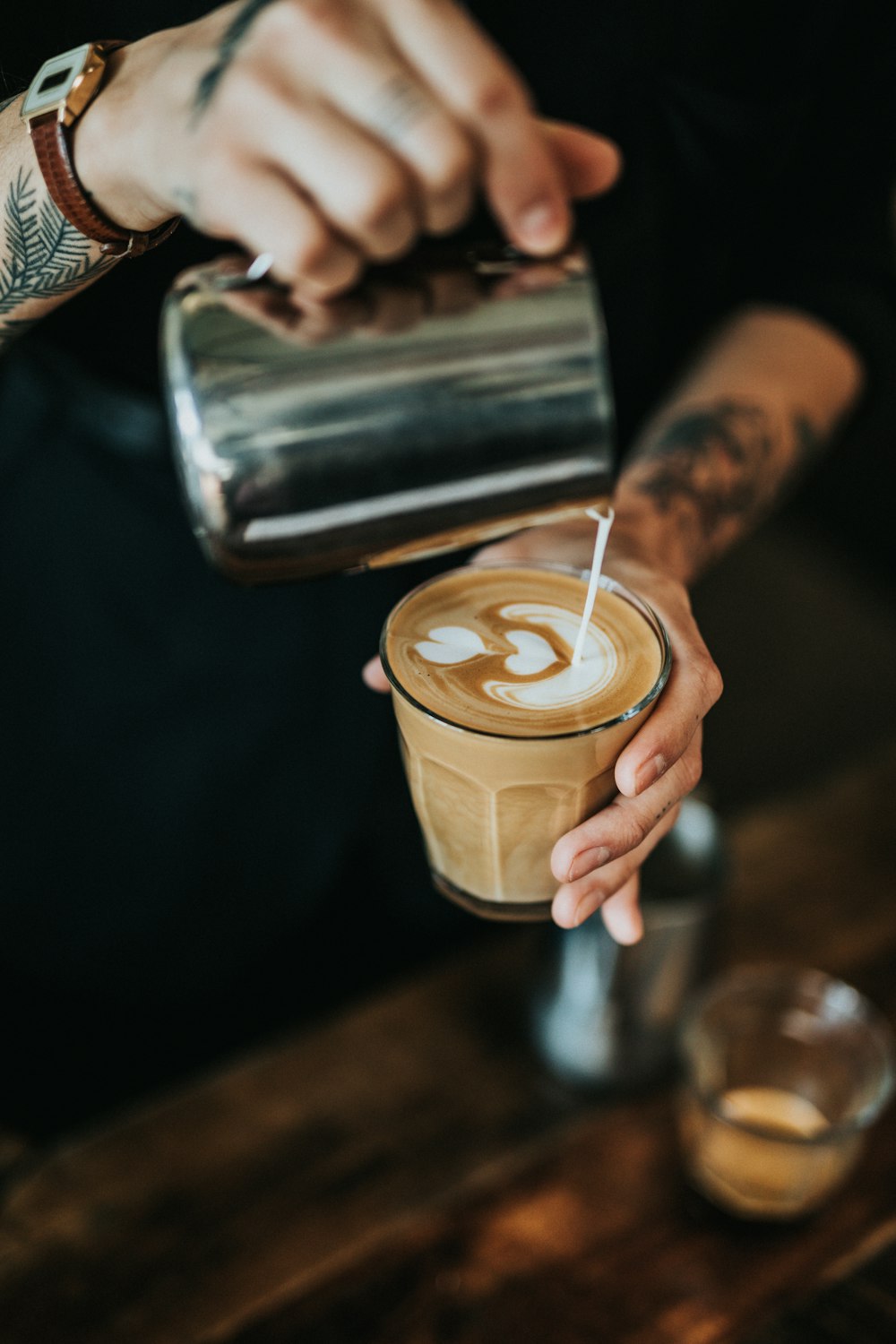 man pouring milk in coffee