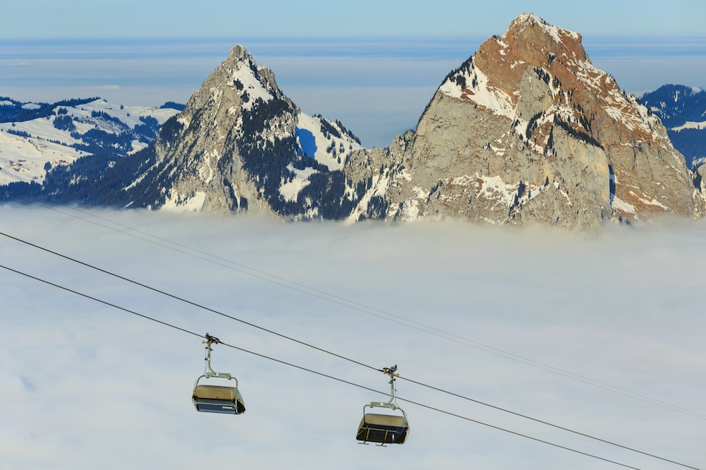 two gray cable cars near rock mountains during daytime