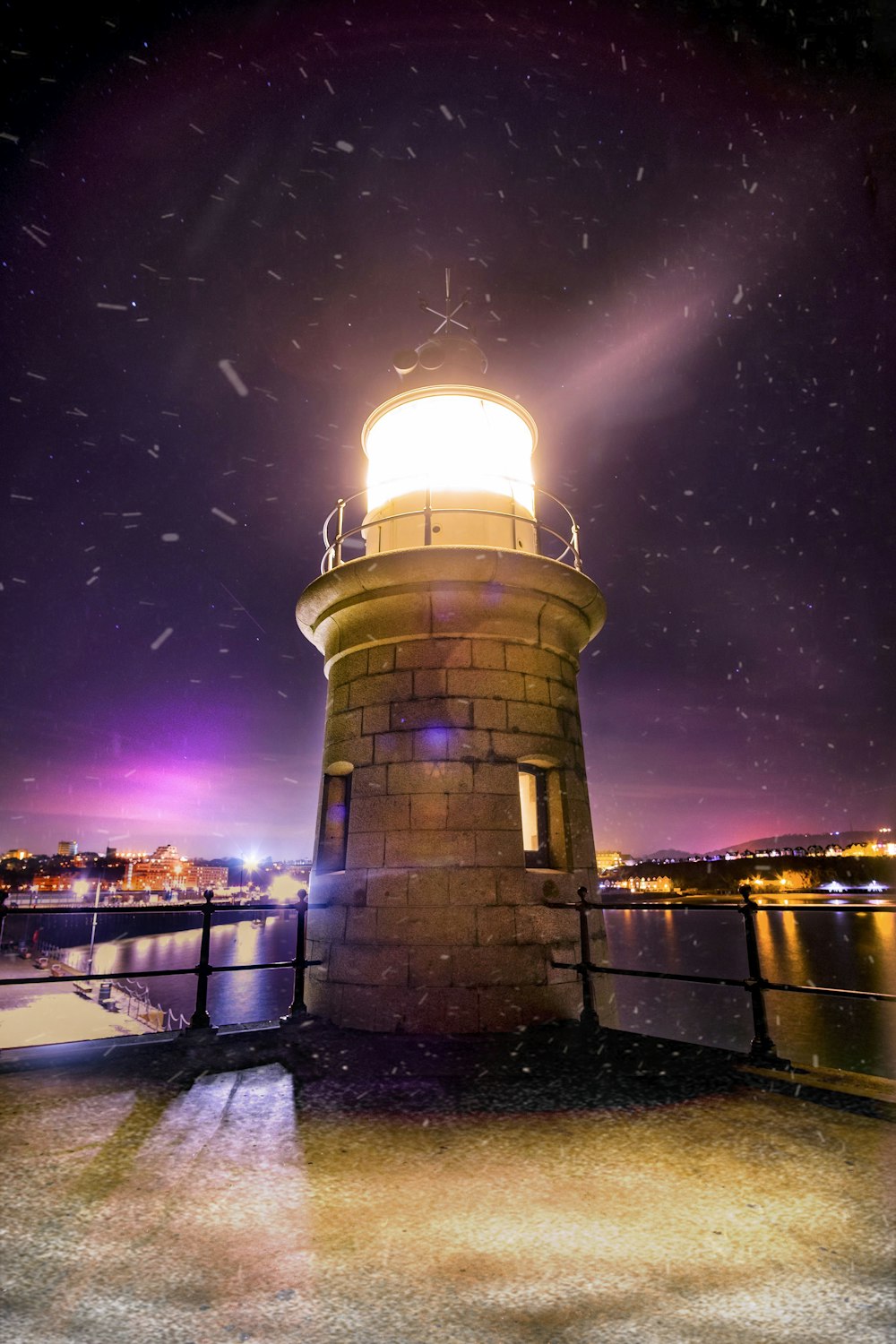 white lighthouse near cityscape