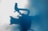 A silhouette of a video camera with a handle is projected against a backdrop of mist or fog. The image has a soft, bluish tint that gives it an ethereal and mysterious quality.