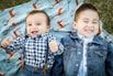 two boys laying on blue textile