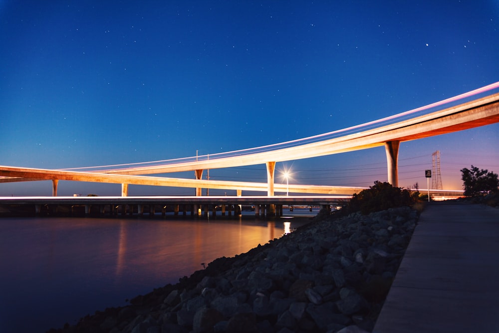 brown bridge and brown wooden dock at nighttime