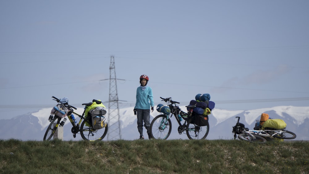 three bicycle on road beside green grass