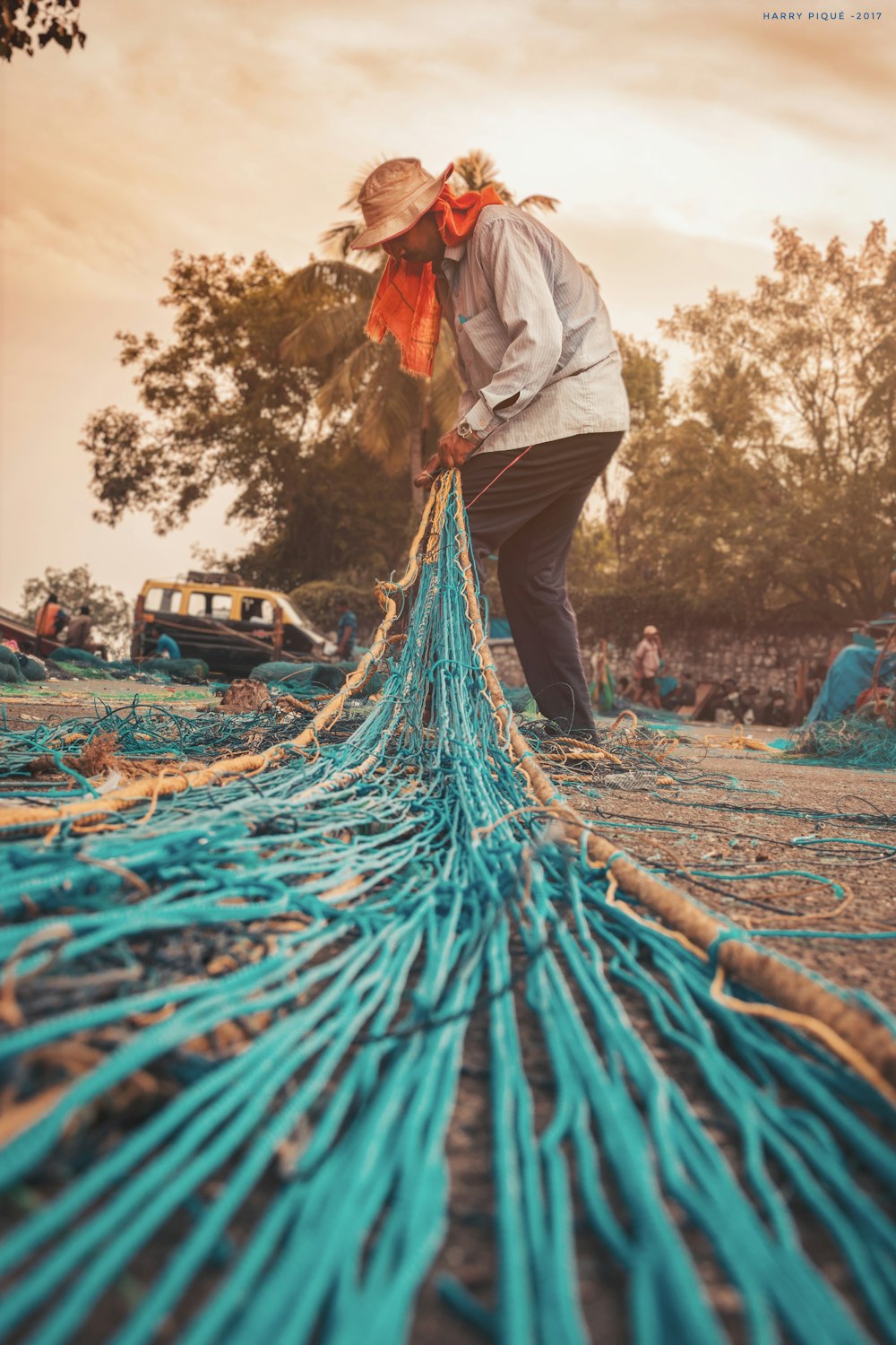 homem tricotando rede de pesca azul