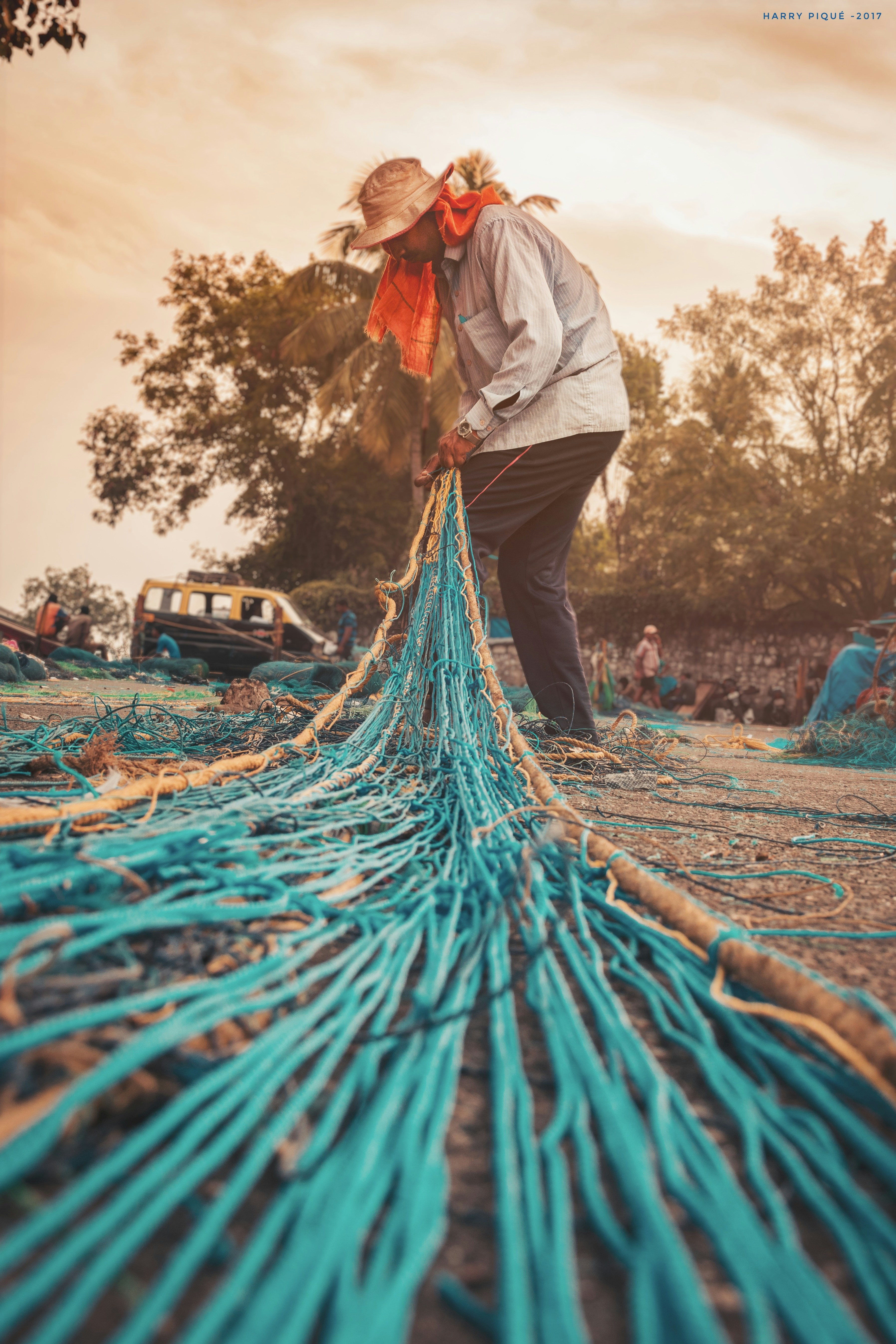 A fisherman weaves and collects strings to form a net and set sailing the next dawn amidst the dramatic ending of the day. . . Natives there have a very planned schedule, hence this evening weaving task.