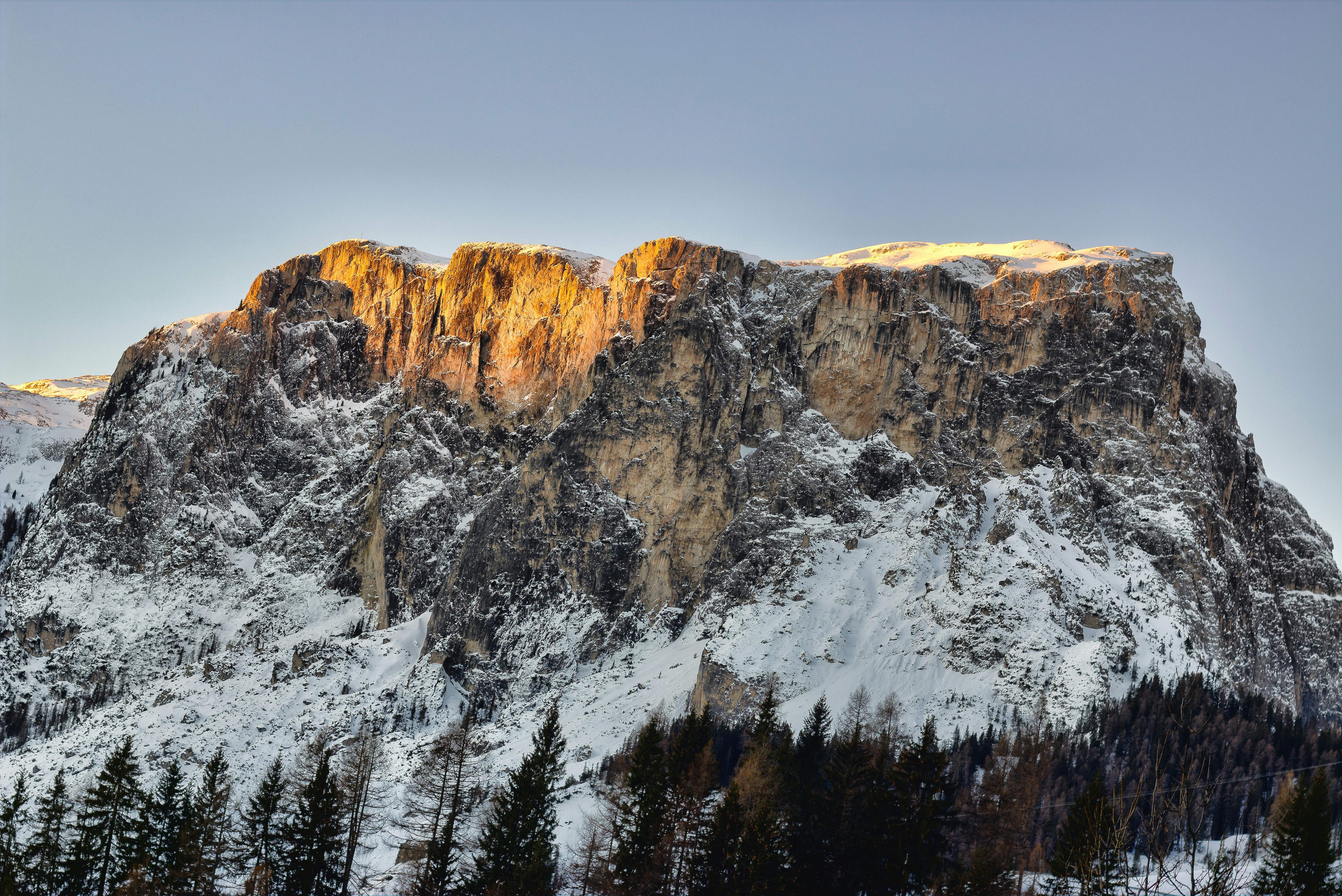Mountain massif, sunbathed, partly covered in show.