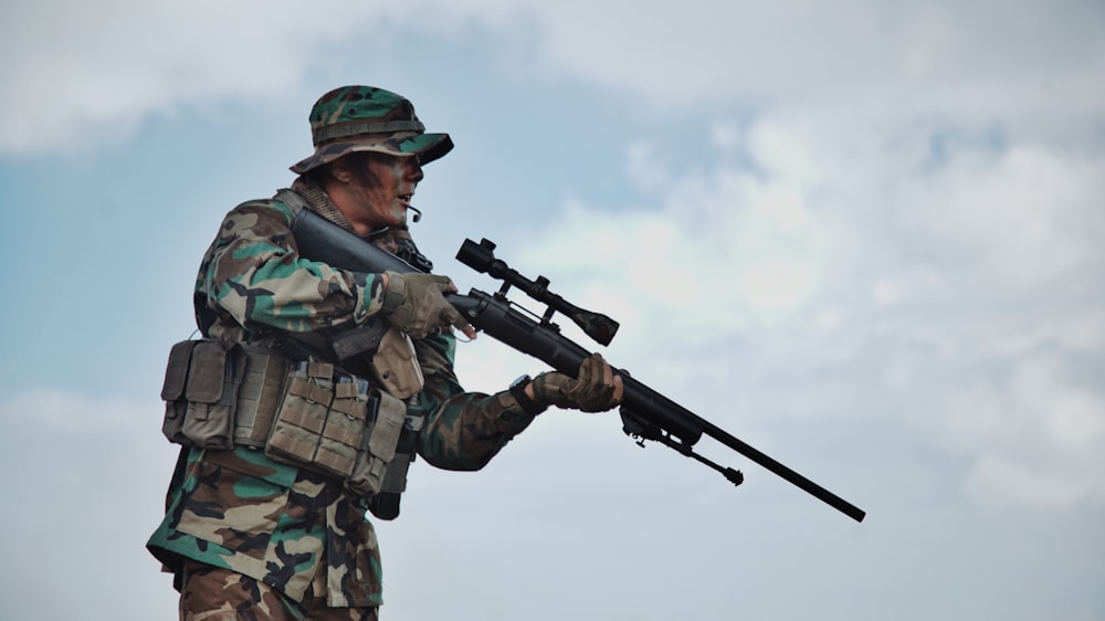 soldado segurando rifle de precisão em pé