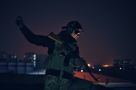 Man at night in body armor and tactical assault panel 