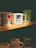 A collection of coffee mugs displayed on a shelf. The prominent mugs include one with 'I ❤ NY' in bold letters, another with a skull and crossbones design labeled 'Death Before Decaf', and a green mug featuring a mermaid pattern. The lighting casts a warm, cozy ambiance over the scene.
