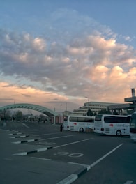 A fleet of rental cars, buses, and tempo travelers ready for departure under a bright sky.