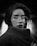 grayscale photo of woman wearing coat and eyeglasses