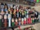 A collection of PEZ dispensers is displayed on a clear shelf, featuring a variety of character heads from popular culture, including superheroes, science fiction figures, and other recognizable characters.
