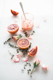 sliced blood orange fruits with white-and-pink petaled flowers beside