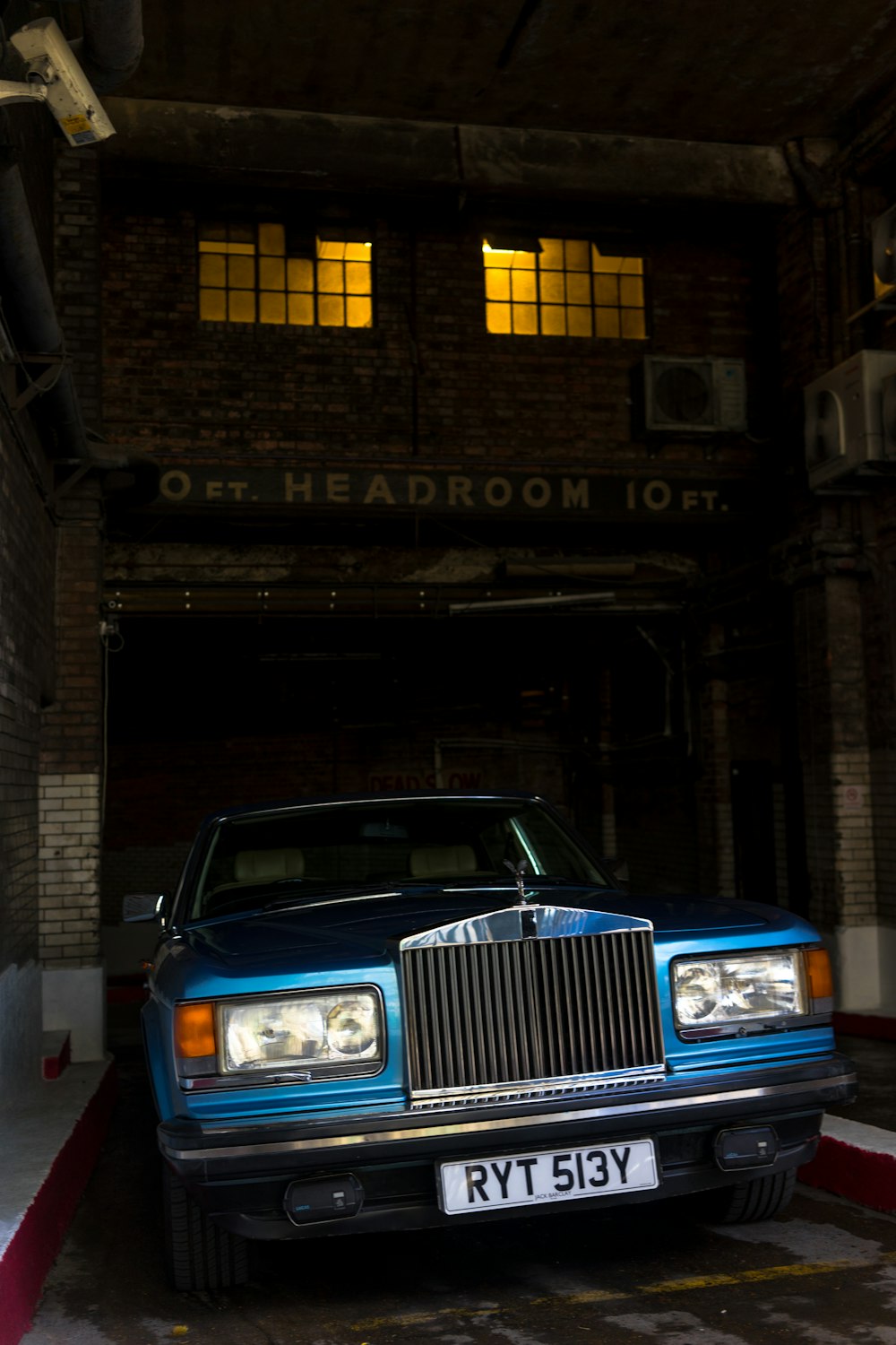 헤드룸 건물 근처에 주차된 클래식 블루 자동차