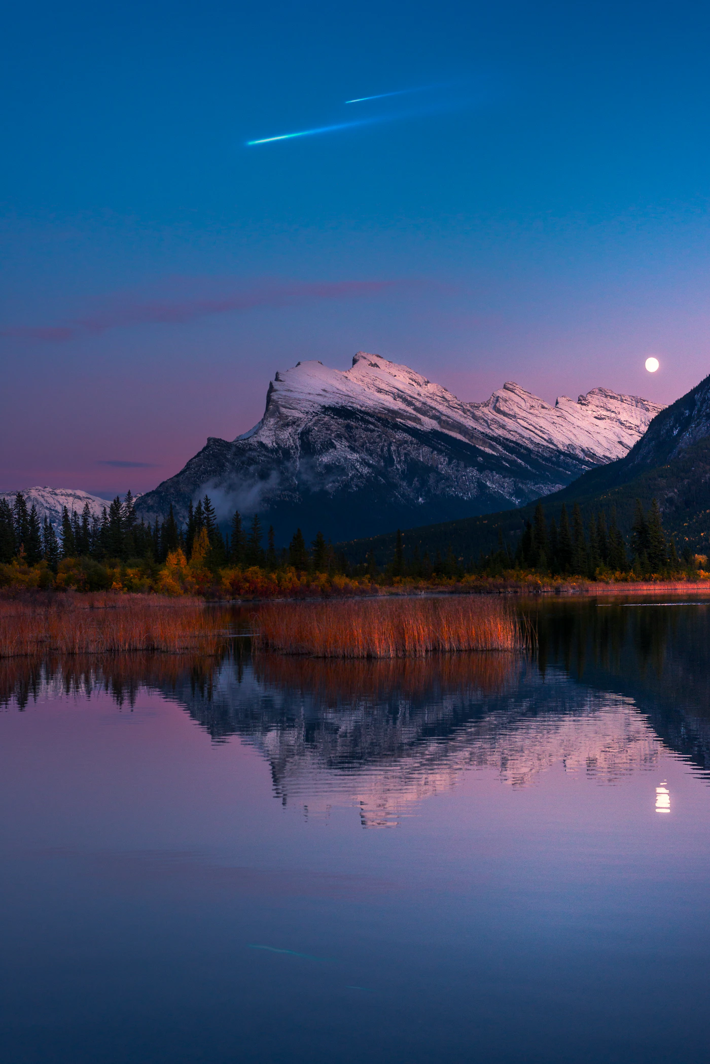 Golden hour light over Vermillion Lakes viewpoint in Banff with warm sky reflected in the water