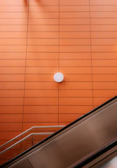 Before and after shot of a renovated commercial lobby, featuring sleek surfaces and safety orange accent lighting.