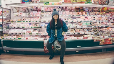 A friendly shopkeeper arranging fresh food products on store shelves.